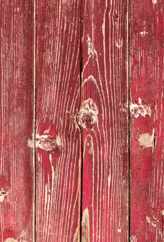 Wooden red planks. Background consisting of wooden planks with peeling red paint.