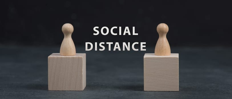 Two woooden people keep social distance, Covid-19 pandemic regulations