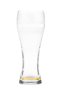 Almost empty beer glass. Light lager beer remains in a tall glass. Isolated on white background