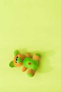 Rabbit teddy bear on yellow color background. Table top view. Vertical. Flat lay. Copy space for text.