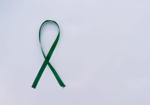 Green Ribbon on white background. Table top view. copy space for text.