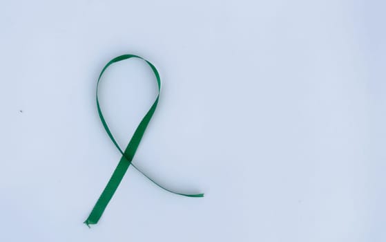 Green Awareness Ribbon on white background. Table top view. Health care and medical. Copy space for text.