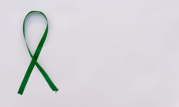 Green Awareness Ribbon on white background. Table top view. Health care and medical. Copy space for text.