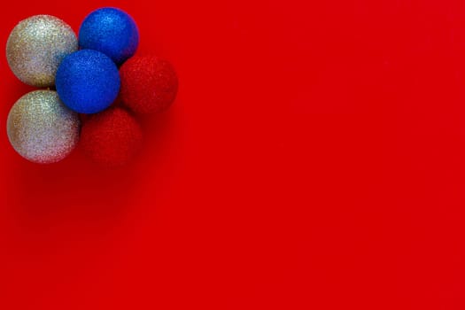 Christmas balls of silver blue and red color are in the shape of a flower on a red background. New Year, the flag of Russia, top view, flat lay, copy space, isolate