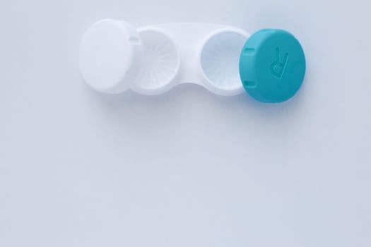 The open container for storing lenses lies on top on a white background with a place for text.top view, flat lay, copy space, isolate. High quality photo