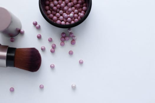 Blush balls of pink and cream color and a brush for applying blush on a white background with a place for text. top view, flat lay, copy space, isolate. High quality photo