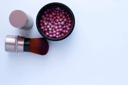 Blush balls of pink and cream color and a brush for applying blush on a white background with a place for text. top view, flat lay, copy space, isolate. High quality photo