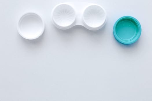 The open container for storing lenses lies on top on a white background with a place for text.top view, flat lay, copy space, isolate. High quality photo