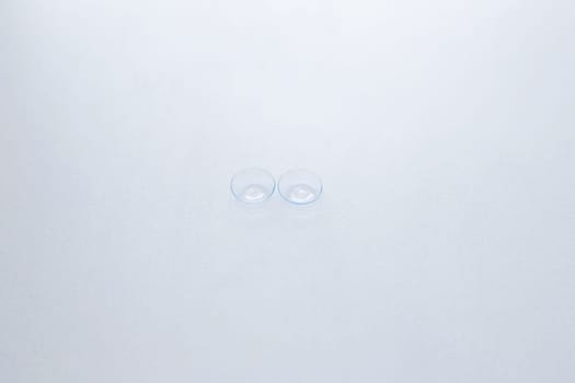 Two contact lenses lie in the center on a white background.top view, flat lay, copy space, isolate. High quality photo