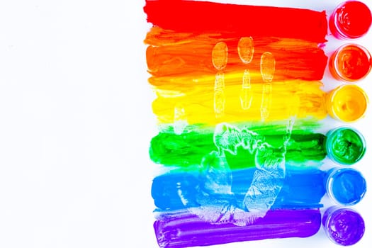 Colorful lines drawn horizontally with paint in the form of a rainbow with a handprint on a white background. LGBT PEOPLE. top view, flat lay, copy space, isolate. High quality photo