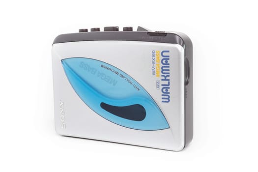 Sony Walkman. Vintage portable audio tape compact cassette player with headphones and cassette. Device on white background. Bergamo, ITALY - March 24, 2021.