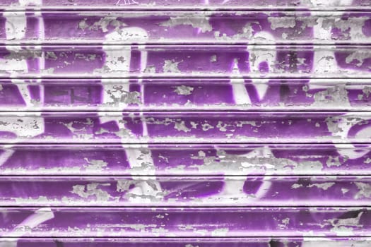Violet metal shutter with peeling paint. Ideal use for background / wallpaper.