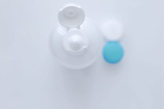 The lens container and the lens storage liquid lie in the center on a white background. top view, flat lay, copy space, isolate. High quality photo
