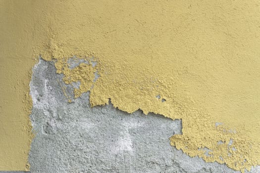 Plaster. Old destroyed yellow plaster. Vintage background of weathered peeling plaster.