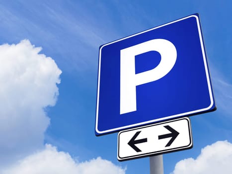 Car parking directional sign against a partly cloudy sky background