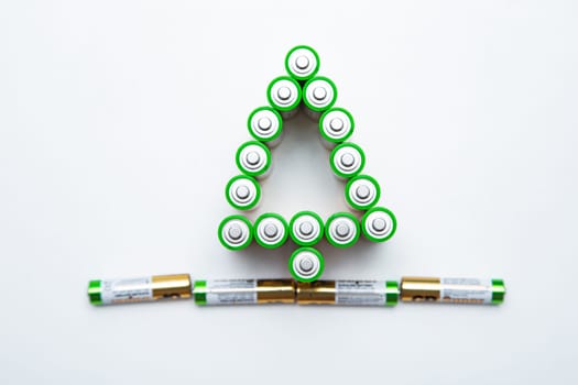 The batteries are in the shape of a Christmas tree on a white background. top view, flat lay, copy space, isolate. High quality photo