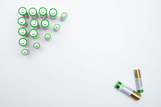 The batteries are placed in a triangle in the upper corner of the photo, in the opposite lower corner there are two batteries on a white background. top view, flat lay, copy space, isolate. High quality photo