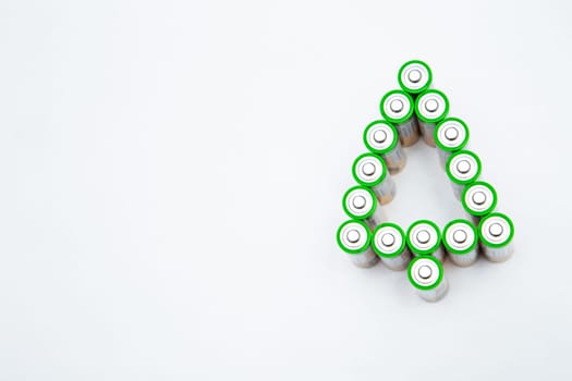 The batteries are in the shape of a Christmas tree on a white background. top view, flat lay, copy space, isolate. High quality photo