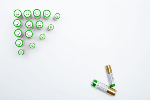 The batteries are placed in a triangle in the upper corner of the photo, in the opposite lower corner there are two batteries on a white background. top view, flat lay, copy space, isolate. High quality photo
