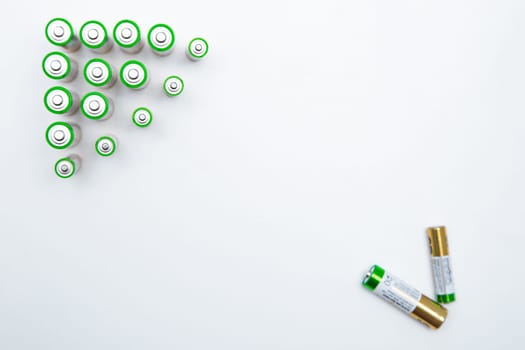 The batteries are placed in a triangle in the upper corner of the photo, in the opposite lower corner there are two batteries on a white background. top view, flat lay, copy space, isolate. High quality photo