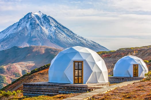 The Glamping house and volcano, rural landscape, tent houses in Kamchatka peninsula. Selective focus.