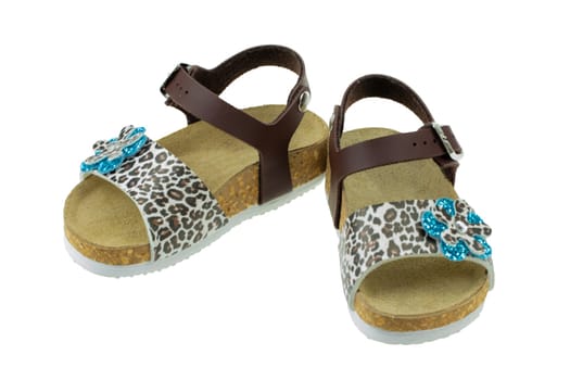Summer shoes isolated. Close-up of a pair of girls sandals adorned with a blue flower set with rhinestones isolated on a white background. Childrens summer fashion. Macro.