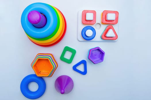 Children's educational toys: a pyramid and sorters lie on a white background with a place for text. top view, flat lay, copy space, isolate. High quality photo