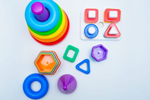 Children's educational toys: a pyramid and sorters lie on a white background with a place for text. top view, flat lay, copy space, isolate. High quality photo