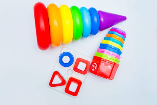 Children's educational toys: a pyramid and sorters lie on a white background. top view, flat lay, copy space, isolate. High quality photo