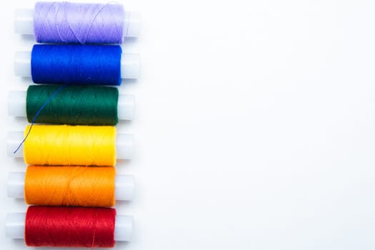 Skeins with threads are lined up in a row according to the color of the rainbow. top view, flat lay, copy space, isolate High quality photo