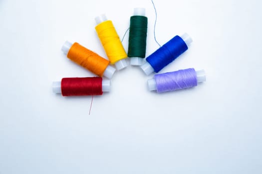 Skeins with threads are lined up in a row according to the color of the rainbow. top view, flat lay, copy space, isolate High quality photo