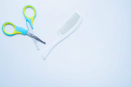Children's scissors for cutting nails and a children's comb are on a white background. top view, flat lay, copy space, isolate. High quality photo