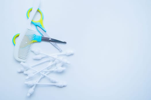 Children's scissors for cutting nails, children's ear sticks and a children's comb are on a white background. High quality photo