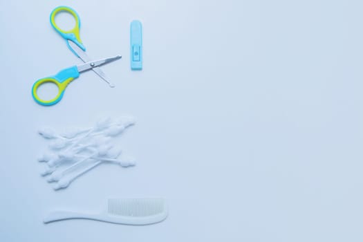 Children's scissors for cutting nails, children's ear sticks and a children's comb are on a white background. High quality photo