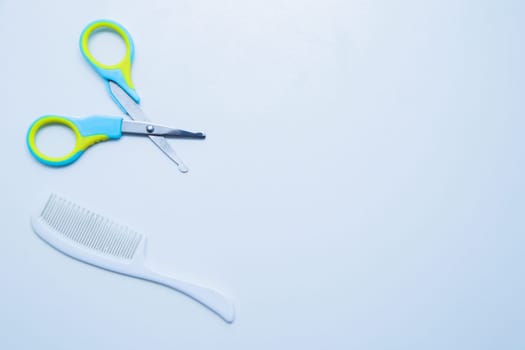 Children's scissors for cutting nails and a children's comb are on a white background. top view, flat lay, copy space, isolate. High quality photo