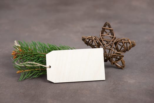 Empty sign with christmas decoration, branch of fir and cones, textured brown background