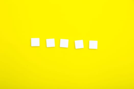 Five white empty squares for letters on a yellow background. High quality photo