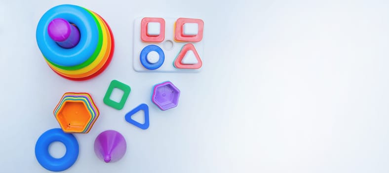 Children's educational toys: a pyramid and sorters lie on a white background with a place for text. top view, flat lay, copy space, isolate. High quality photo