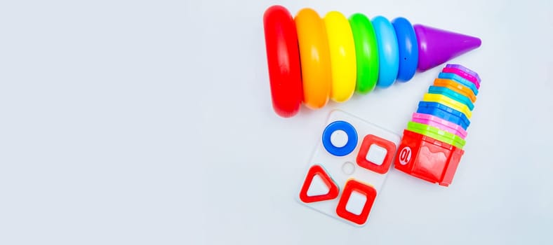 Children's educational toys: a pyramid and sorters lie on a white background with a place for text. top view, flat lay, copy space, isolate. High quality photo