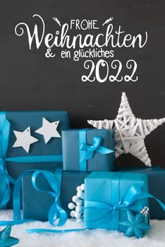 German Calligraphy Frohe Weihnachten Und Ein Glueckliches 2022 Means Merry Christmas And A Happy 2022. Turquoise Gift With Bow And Decoration Like Star. Black Background With Snow