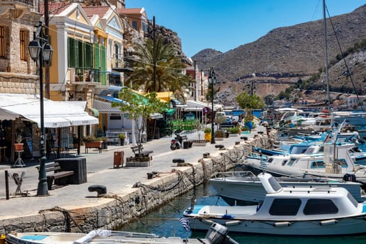 SYMI, Greece - JUN 03, 2021. The harbour of Symi town with the districts of Chorio and Gialos is one of the most beautiful and romantic in the whole Aegean. Colourful mansions stretch up the steep slopes.