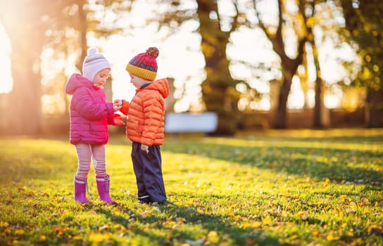 Two children playing in the park together. Concept of family relationship and friendship.