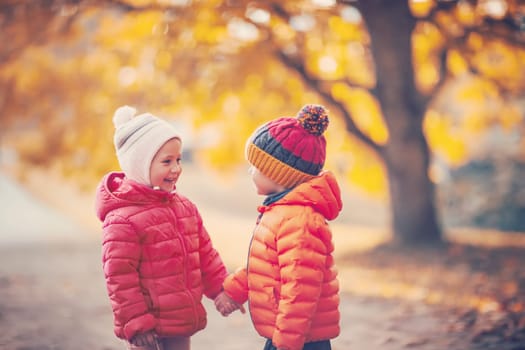 Two children playing in the park together. Concept of family relationship and friendship.