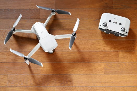 small drone copter with controller on a wooden background