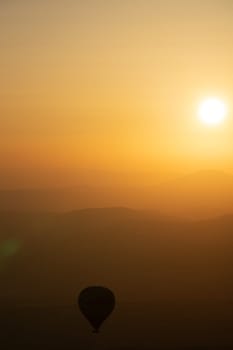 landscape with hot air balloons black silhouette rising up to the sky at sunrise with beautiful high mountain panorama in the background
