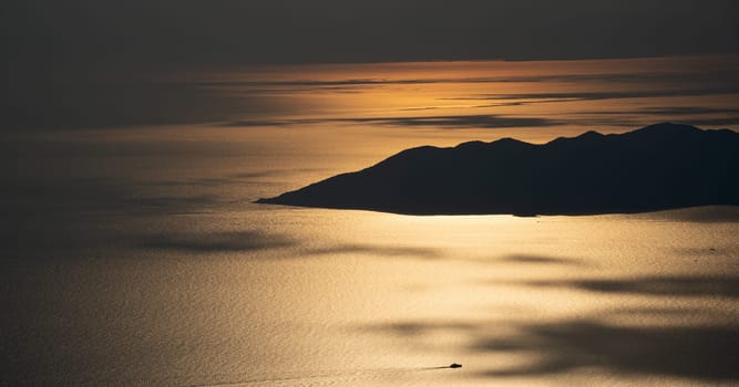 beautiful aerial panorama from the Babadag peak of high mountains rising up over the Mediterranean sea at sunset near Oludeniz Blue Lagoon coast in Turkey during summer