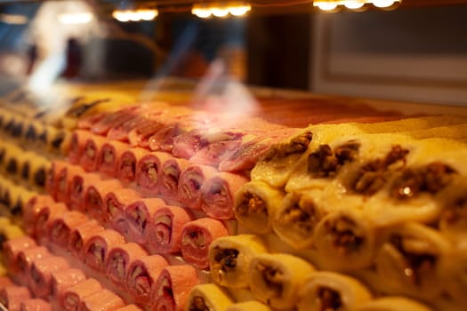 rows of Turkish delight sweets desserts with dried fruits arranged in a pyramid shape and lined up in the store window