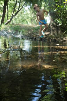 Little boy throwing pebbles into the water. Holidays where kids can go wild concept