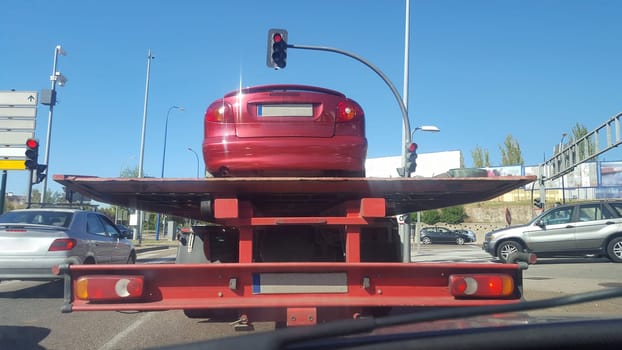 Driving on city behind a slow tow truck. View from the inside of the car