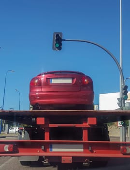 Driving on city behind a slow tow truck. View from the inside of the car